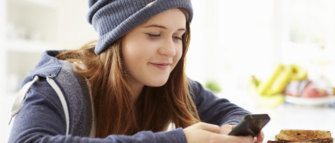 A child writing on a smartphone