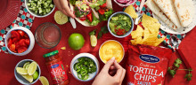 Table of Tex Mex with hands grabbing food