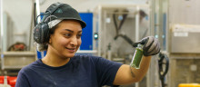 Women in factory holding a spice jar with oregano